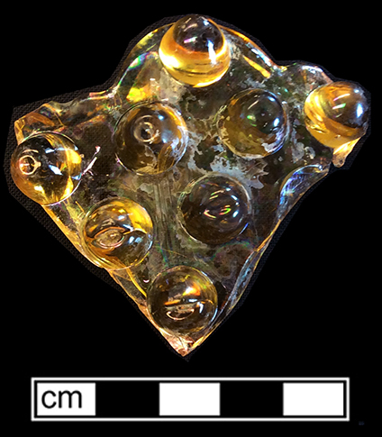 Amber glass unidentified hollow vessel with a molded hobnail motif. 18BC163